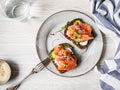 Healthy toasts with rye bread with cream cheese, salmon, fresh cucumber, capers, sesame seeds, black pepper and arugula on plate. Royalty Free Stock Photo