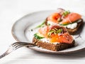 Healthy toasts with rye bread with cream cheese, salmon, fresh cucumber, capers, sesame seeds, black pepper and arugula Royalty Free Stock Photo