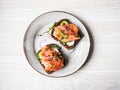 Healthy toasts with rye bread with cream cheese, salmon, fresh cucumber, capers, sesame seeds, black pepper and arugula on plate. Royalty Free Stock Photo