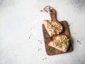 Healthy toasts with salmon pate and fresh green sprouts on yeast-free bread on wood cutting board on grey background. Copy space