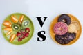 Healthy and unhealthy, Fruit plate vs biscuit plate, Concept, Good food choice, Bright background Royalty Free Stock Photo