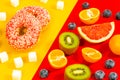 Healthy and unhealthy sugar, yellow red background, juicy fruit next to sweet donut and processed sugar, Healthy eating concept Royalty Free Stock Photo
