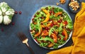 Healthy vegan eating, autumn pumpkin salad with baked honey pumpkin slices, lettuce, arugula, pomegranate seeds and walnuts. Royalty Free Stock Photo