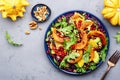 Healthy vegan eating, autumn pumpkin salad with baked honey pumpkin slices, lettuce, arugula, pomegranate seeds and walnuts. Royalty Free Stock Photo