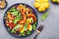Healthy vegan eating, autumn pumpkin salad with baked honey pumpkin slices, lettuce, arugula, pomegranate seeds and walnuts. Royalty Free Stock Photo