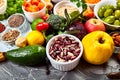 Healthy vegan food. Assortment of organic vegetables and fruits with legumes, nuts on grey background. Royalty Free Stock Photo