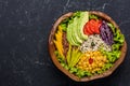 Healthy vegan food bowl with quinoa, wild rice, chickpea, tomatoes, avocado, greens, cabbage, lettuce on black stone background Royalty Free Stock Photo