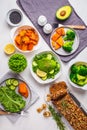 Healthy vegan food dinner table, top view. Green salad, sweet potato, vegan cake, vegetables on white background Royalty Free Stock Photo