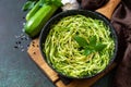 Healthy vegan food, low carb dish. Cooked zucchini noodles with basil and garlic in a cast iron pan Royalty Free Stock Photo