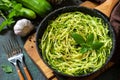 Healthy vegan food, low carb dish. Cooked zucchini noodles with basil and garlic in a cast iron pan