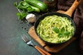 Healthy vegan food, low carb dish. Cooked zucchini noodles with basil and garlic in a cast iron pan Royalty Free Stock Photo