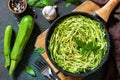 Healthy vegan food, low carb dish. Cooked zucchini noodles with basil and garlic in a cast iron pan Royalty Free Stock Photo