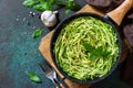 Healthy vegan food, low carb dish. Cooked zucchini noodles with basil and garlic in a cast iron pan Royalty Free Stock Photo