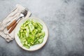 Healthy vegan green avocado salad bowl with sliced cucumbers, edamame beans, olive oil and herbs on ceramic plate top Royalty Free Stock Photo