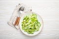 Healthy vegan green avocado salad bowl with sliced cucumbers, edamame beans, olive oil and herbs on ceramic plate top Royalty Free Stock Photo