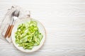 Healthy vegan green avocado salad bowl with sliced cucumbers, edamame beans, olive oil and herbs on ceramic plate top Royalty Free Stock Photo