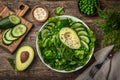 Healthy vegan green salad with avocado, broccoli, cucumber, green peas and spinach in white  bowl Royalty Free Stock Photo