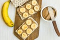 Healthy vegan homemade chunky peanut butter and banana sandwich with Swedish whole grain crispbread on wood cutting board,knife