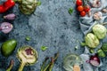 Healthy vegan ingredients layout. Flat-lay of green vegetables and herbs over light blue background with napkin, top view, copy