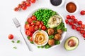 Healthy vegan lunch bowl with falafel hummus tomato avocado peas