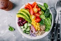 Healthy vegan lunch Buddha bowl. Avocado, quinoa, tomato, cucumber, red beans, spinach, red onion and red paprika vegetables salad Royalty Free Stock Photo
