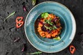 Healthy vegan pumpkin curry salad with with peppers and tomato in ceramic plate over dark background. Healthy food, clean eating,