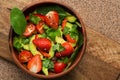 Healthy vegan salad - avocado, spinach, sweet peppers, strawberries, cherry tomatoes and parsley. The concept of healthy eating. Royalty Free Stock Photo