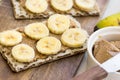 Healthy vegan snack with scandinavian rye crispbread, homemade peanut butter and slices of bananas Royalty Free Stock Photo