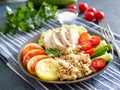 Healthy vegetable buddha bowl lunch with turkey, vegetables and quinoa on blue background. Side view.