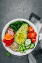 Healthy vegetable lunch Buddha bowl. Avocado, quinoa, tomatoes, cucumbers, radishes, spinach, carrots, paprika and edamame beans s Royalty Free Stock Photo