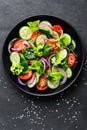 Healthy vegetable salad of fresh tomato, cucumber, onion, spinach, lettuce and sesame on plate. Diet menu