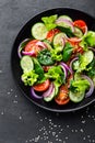 Healthy vegetable salad of fresh tomato, cucumber, onion, spinach, lettuce and sesame on plate. Diet menu Royalty Free Stock Photo