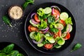 Healthy vegetable salad of fresh tomato, cucumber, onion, spinach, lettuce and sesame on plate. Diet menu Royalty Free Stock Photo