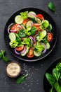 Healthy vegetable salad of fresh tomato, cucumber, onion, spinach, lettuce and sesame on plate. Diet menu Royalty Free Stock Photo