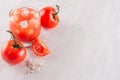 Healthy vegetarian beverage - cold fresh tomato juice with slice, salt, ice cubes on white wood board, copy space, top view.