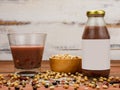 Healthy vegetarian beverage glass bottle and cup on kitchen table with ingredient bowl of soybean grain and brown rice Royalty Free Stock Photo