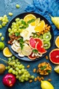 Healthy vegetarian bowl dish with fresh fruits and nuts. Plate with raw apple, orange, grapefruit, banana, kiwi, lemon, grape, alm Royalty Free Stock Photo