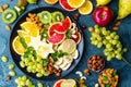 Healthy vegetarian bowl dish with fresh fruits and nuts. Plate with raw apple, orange, grapefruit, banana, kiwi, lemon, grape, alm Royalty Free Stock Photo