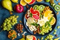 Healthy vegetarian bowl dish with fresh fruits and nuts. Plate with raw apple, orange, grapefruit, banana, kiwi, lemon, grape, alm Royalty Free Stock Photo