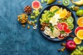 Healthy vegetarian bowl dish with fresh fruits and nuts. Plate with raw apple, orange, grapefruit, banana, kiwi, lemon, grape, alm Royalty Free Stock Photo