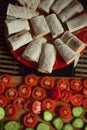 Healthy vegetarian breakfast concept: rolled cheese tacos on red plate with sliced tomatoes and cucumbers on cutting board Royalty Free Stock Photo