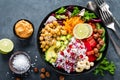 Healthy vegetarian Buddha bowl with fresh vegetable salad, rice, chickpea, avocado, sweet pepper, cucumber, carrot, pomegranate an