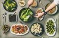 Healthy vegetarian dishes in plates and woman`s hands taking salad