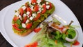 Healthy vegetarian food avocado toast, salad with onion, tomatoes. Top view of tasty toast with mashed avocado spread