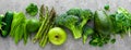 Healthy vegetarian food concept background, fresh green food selection for detox diet, raw broccoli, apple, cucumber, spinach