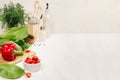 Healthy vegetarian ingredients for spring fresh green salad and kitchenware in white elegant kitchen interior. Royalty Free Stock Photo