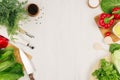 Healthy vegetarian ingredients for spring fresh green salad and kitchenware on white wood board, top view, copy space. Royalty Free Stock Photo