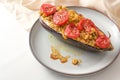 Healthy vegetarian low carb meal, baked eggplant with turmeric, ginger, onions, tomatoes and sesame seed on a plate on a white