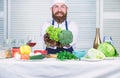Healthy vegetarian recipe. Man cook hat and apron hold broccoli. Organic vegetables. Healthy nutrition concept. Bearded Royalty Free Stock Photo