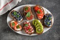 Healthy vegetarian sandwiches made from rye bread with soft cheese, organic berries and fruits - strawberries, blueberries, kiwi, Royalty Free Stock Photo